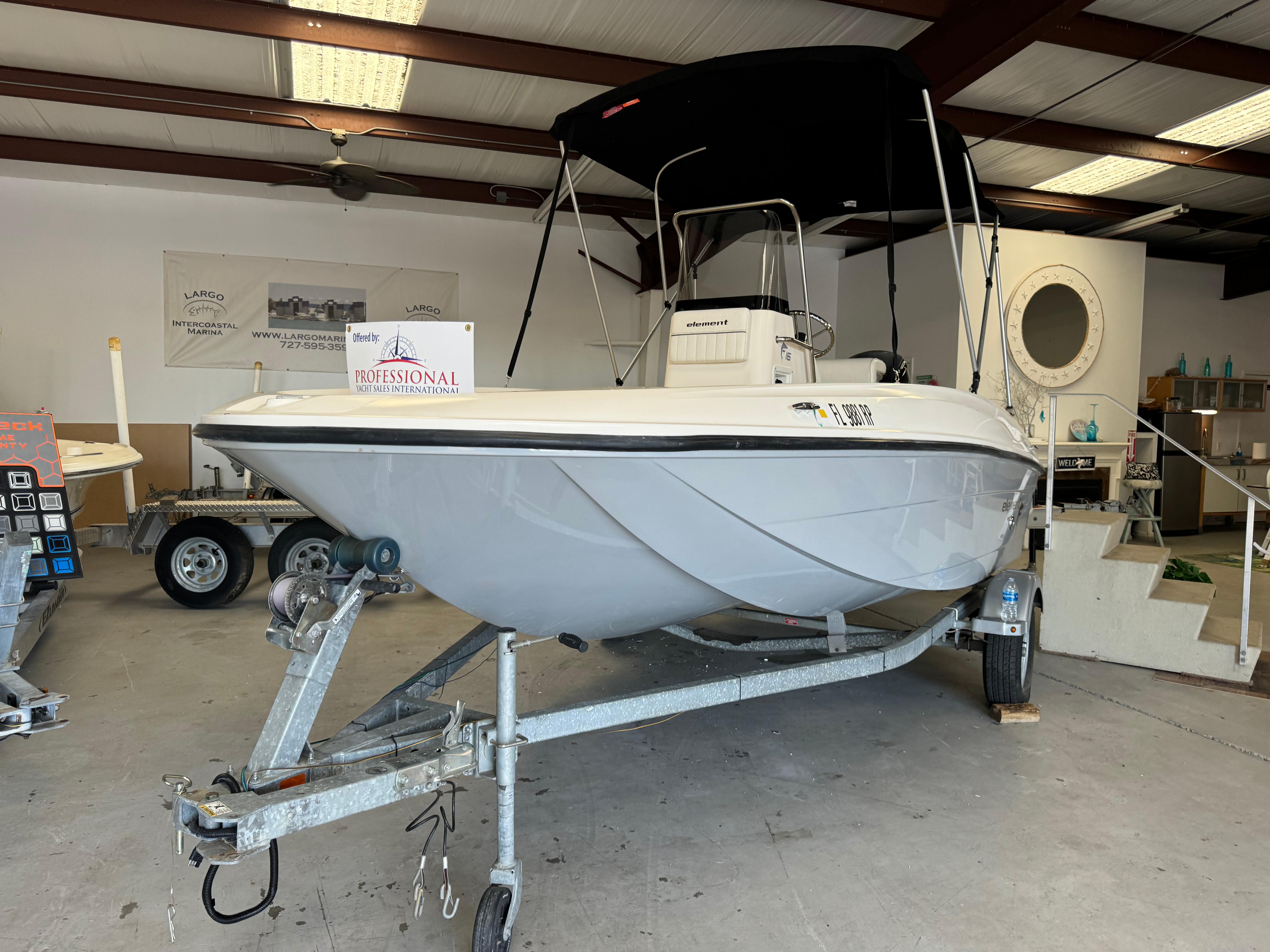 Bayliner Element E16 2018 Bayliner Element E16 boat on trailer in indoor showroom.