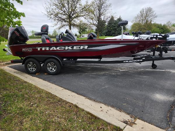 Tracker Savage 215 2025 Tracker Savage 215 boat on trailer, parked outdoors, featuring sleek design and dual motors.