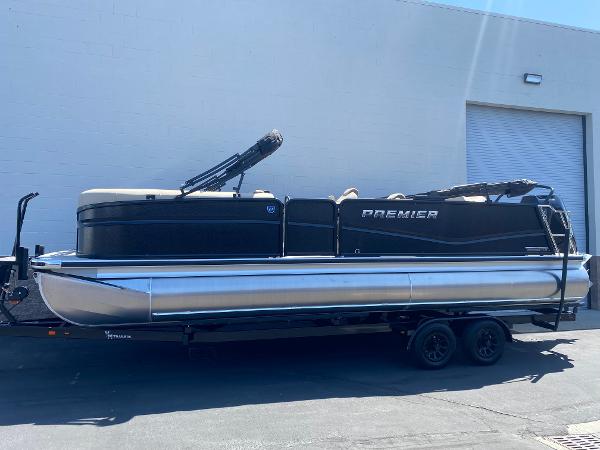 Premier 250 Solaris RL 2025 Premier 250 Solaris RL pontoon boat parked outside a warehouse.