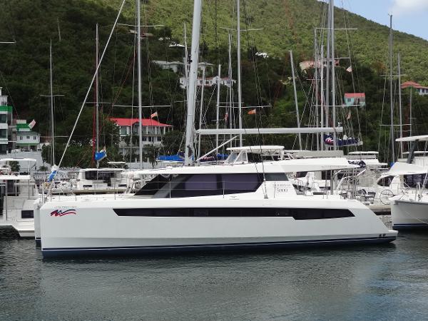 Leopard 50 2019 Leopard 50 catamaran docked in a marina, surrounded by lush green hills.