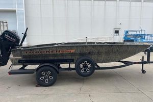 Tracker Grizzly 1756 T Marsh 2026 Tracker Grizzly 1756 T Marsh boat on trailer, camo design, parked outdoors.
