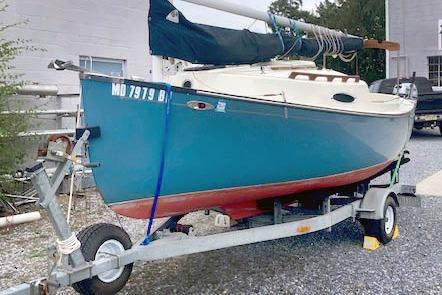 Com-Pac Sun Cat 2002 Com-Pac Sun Cat sailboat on trailer, blue hull, docked outdoors.