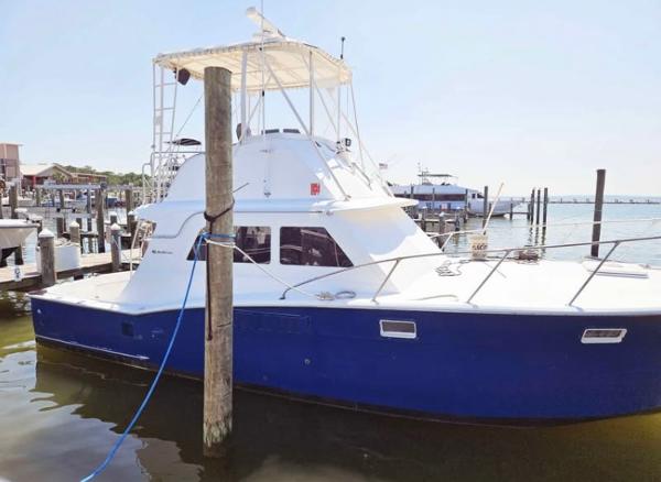 Hatteras 36 Convertible 1975 Hatteras 36 Convertible boat docked at marina, blue hull, white cabin.