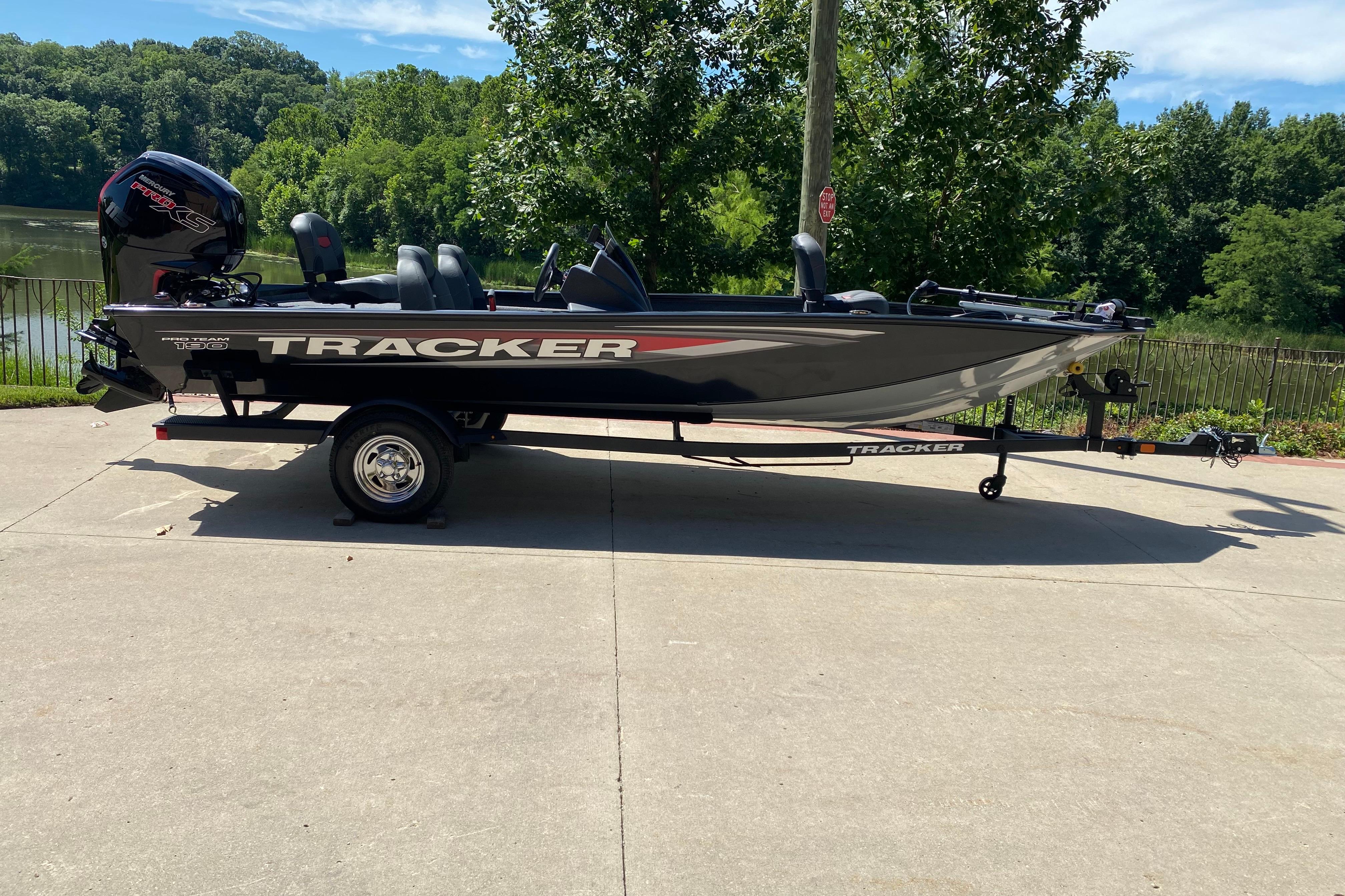 Tracker Pro Team 190 2026 Tracker Pro Team 190 boat on trailer, parked near a scenic lake.
