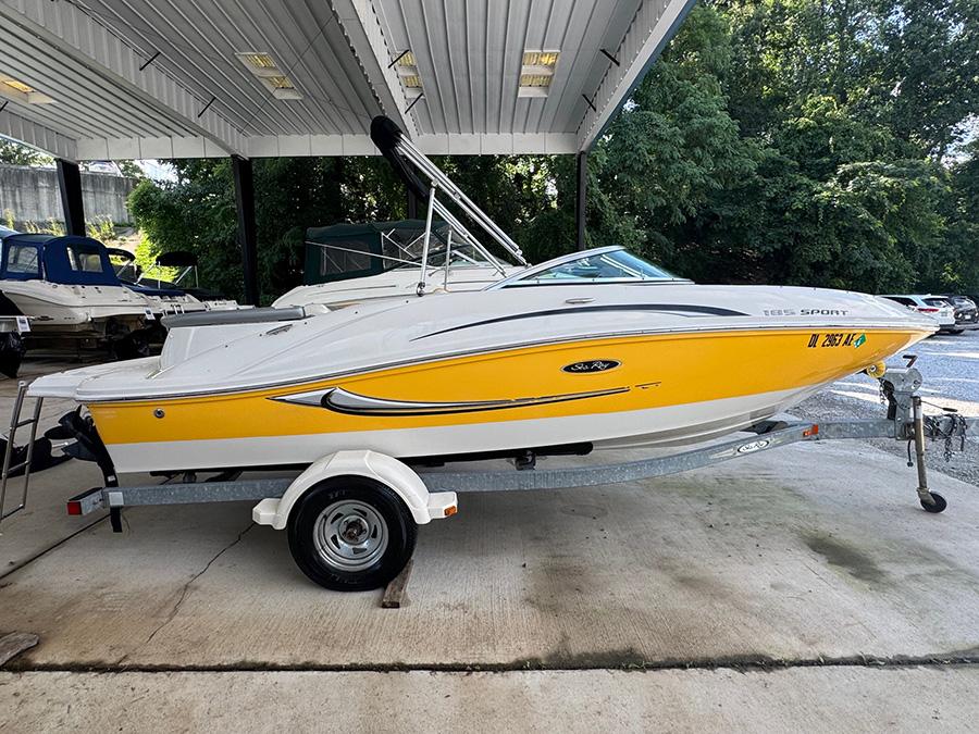 Sea Ray 185 Sport 2008 Sea Ray 185 Sport boat with yellow hull on trailer, parked under shelter.