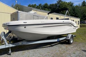 Bayliner DX 2050 2024 Bayliner DX 2050 boat on trailer, parked outdoors near a building.