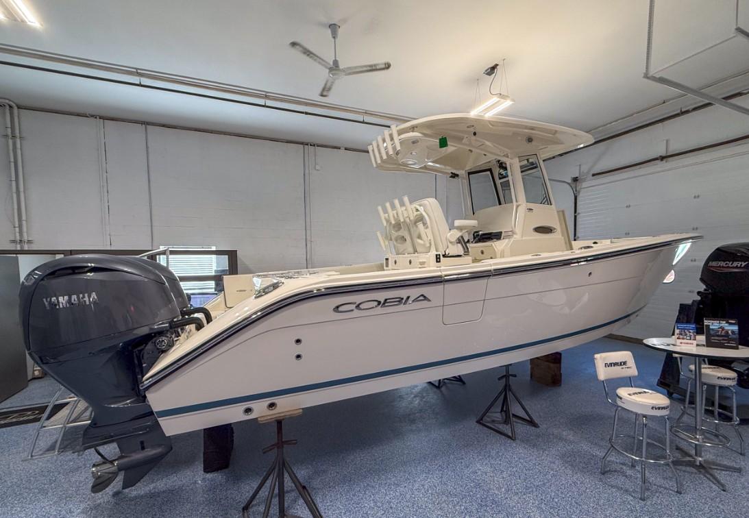 Cobia 265 Open Center Console 2025 Cobia 265 Open Center Console boat displayed indoors with Yamaha engine.