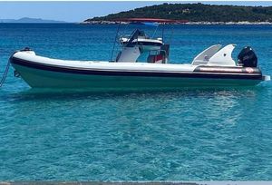 Bura 10 A 2021 Bura 10 boat floating on clear turquoise water near a scenic coastline.