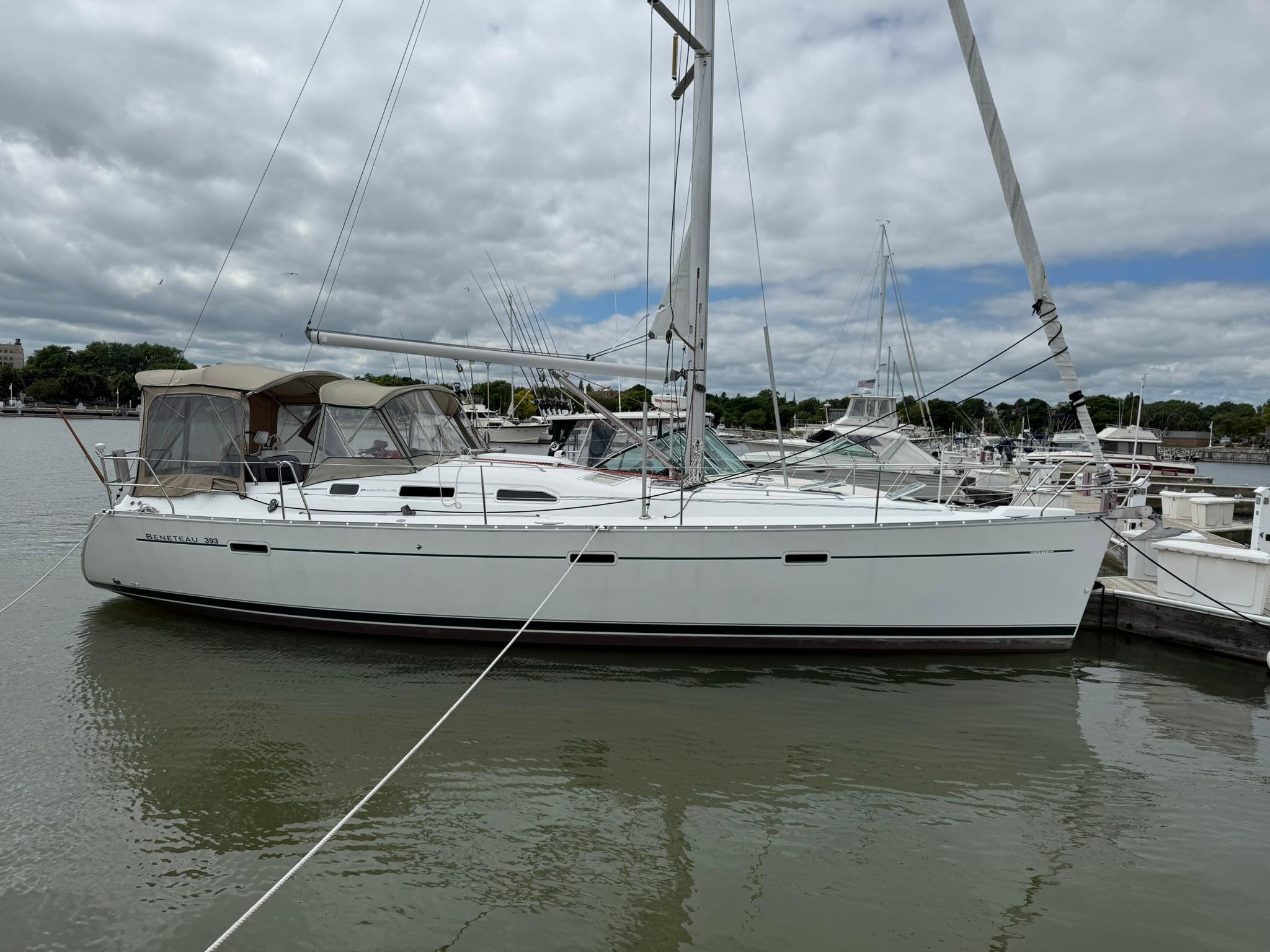 Beneteau 393 2003 Beneteau 393 sailboat docked at marina under cloudy sky.