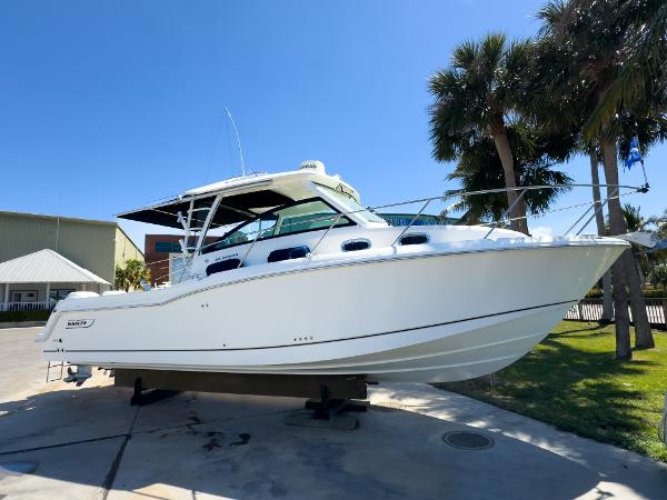 Boston Whaler 315 Conquest 2018 Boston Whaler 315 Conquest boat displayed outdoors with palm trees in the background.