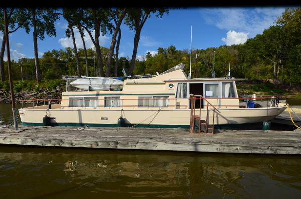 Whitcraft 45 1971 Whitcraft 45 boat docked on a calm river with lush green trees.