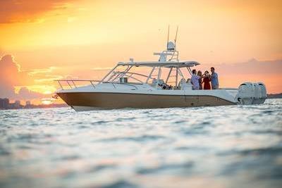 Everglades 360LXC 2016 Everglades 360LXC boat cruising at sunset with passengers on board.