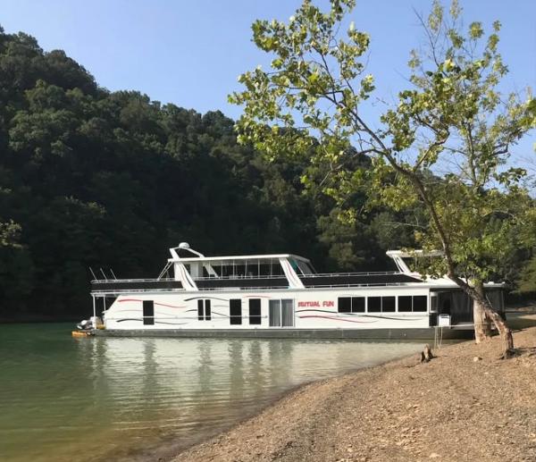 Fantasy Houseboat Fantasy 2006 houseboat on a serene lake, surrounded by lush greenery.