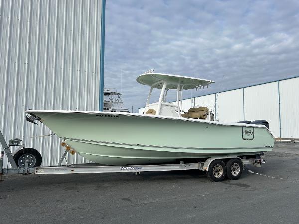 Sea Hunt Gamefish 27 2016 Sea Hunt Gamefish 27 boat on trailer, parked near a large building.