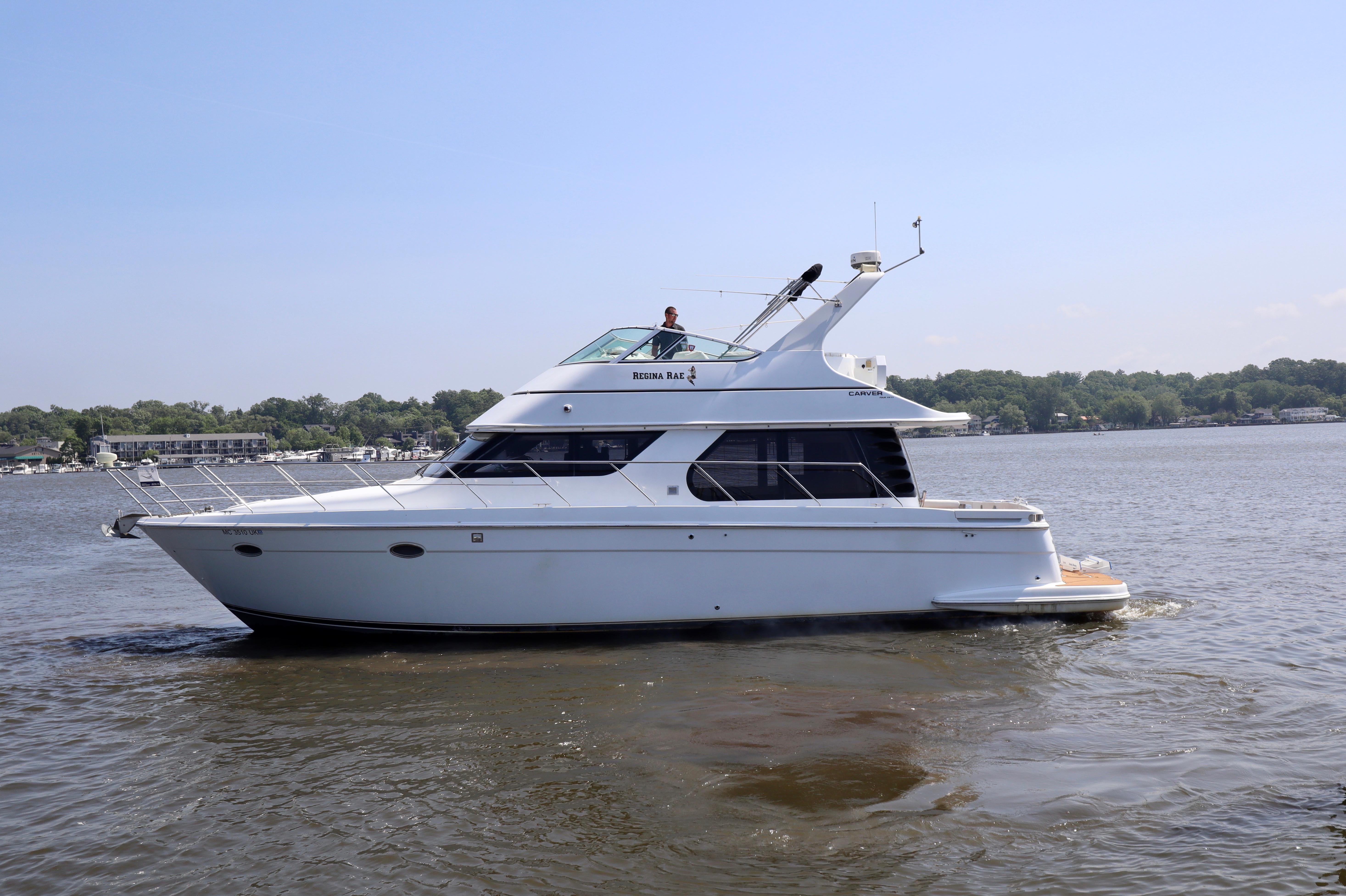 Carver 450 Voyager Pilothouse 1999 Carver 450 Voyager Pilothouse yacht cruising on a calm lake.