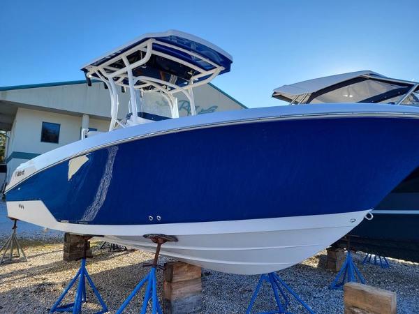 Wellcraft 242 Fisherman 2023 Wellcraft 242 Fisherman boat in vibrant blue, displayed on stands outdoors.