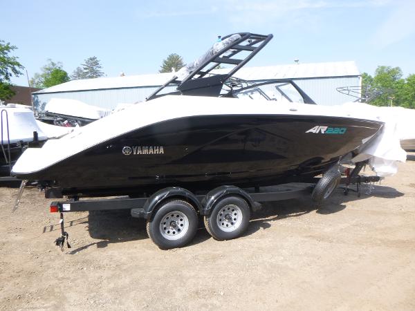 Yamaha Boats AR220 2025 Yamaha Boats AR220 on trailer, black and white design, parked outdoors.