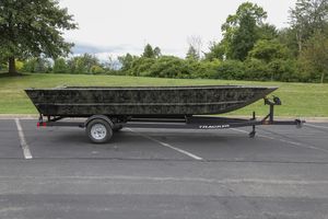 Tracker Grizzly 2072 Utility 2026 Tracker GRIZZLY 2072 Utility boat on trailer in parking lot.