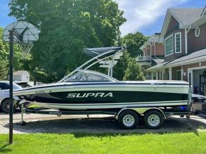 Supra 22 SSV 2007 Supra 22 SSV boat on trailer in residential driveway, sunny day.