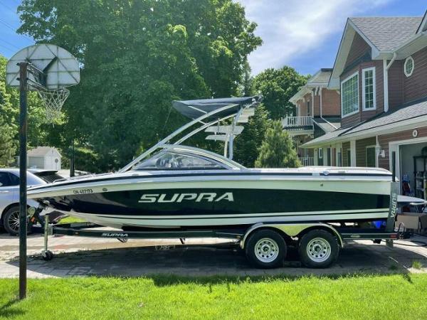 Supra 22 SSV 2007 Supra 22 SSV boat on trailer in residential driveway, sunny day.