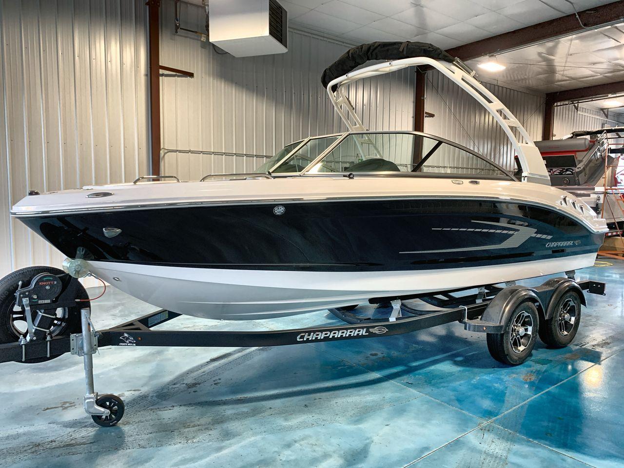 Chaparral 21 SSi 2025 Chaparral 21 SSi boat on trailer in indoor showroom.