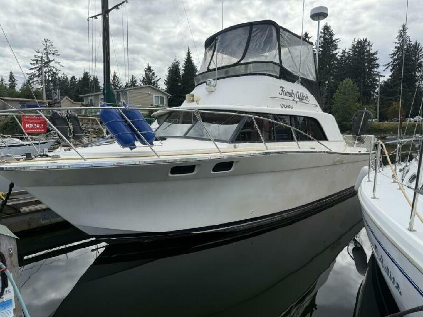 Silverton 34 Convertible 1980 Silverton 34 Convertible boat docked, with "For Sale" sign, under cloudy sky.