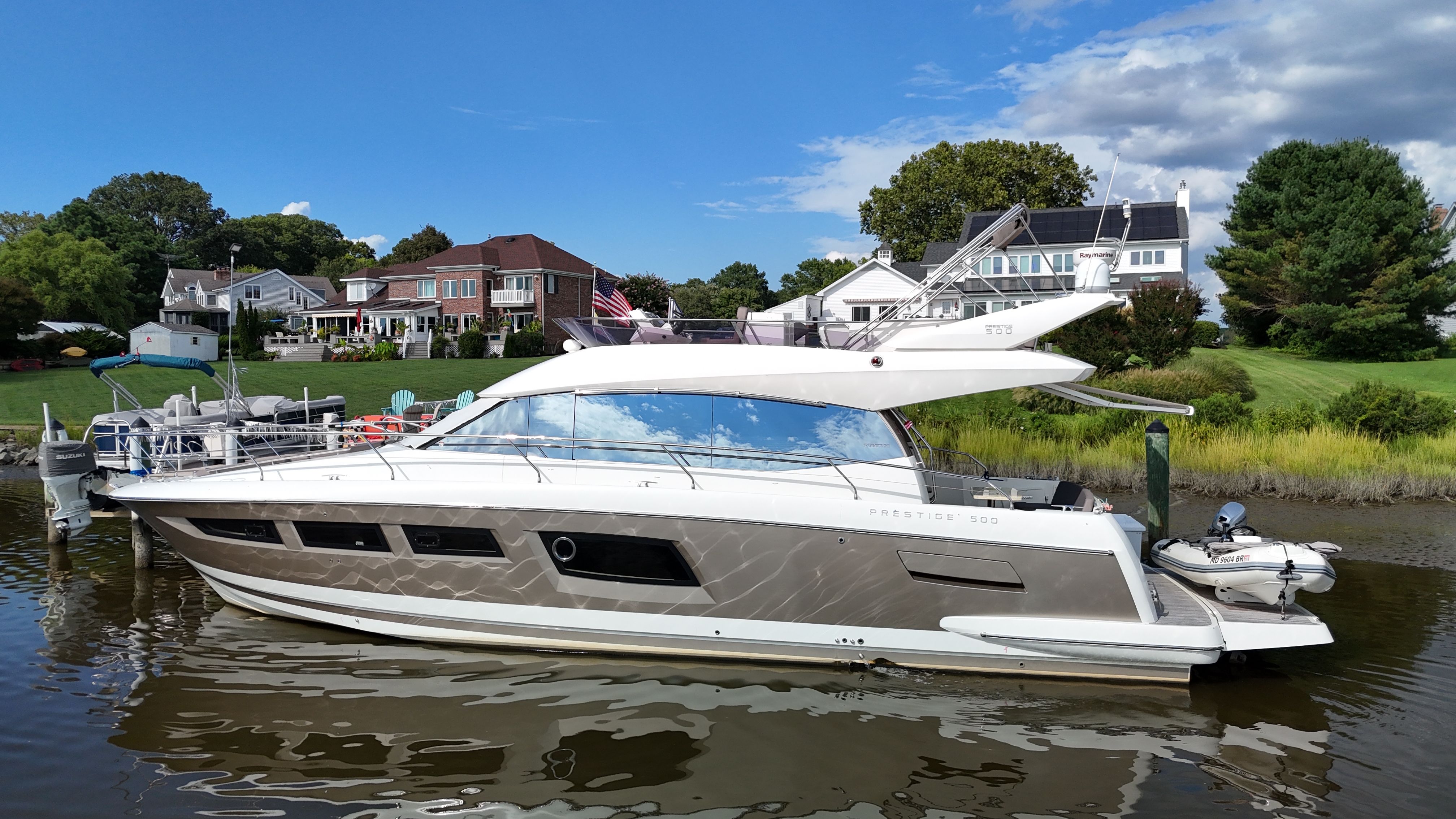 Prestige 500 with SeaKeeper 2016 Prestige 500 yacht with SeaKeeper, docked near waterfront homes under a blue sky.