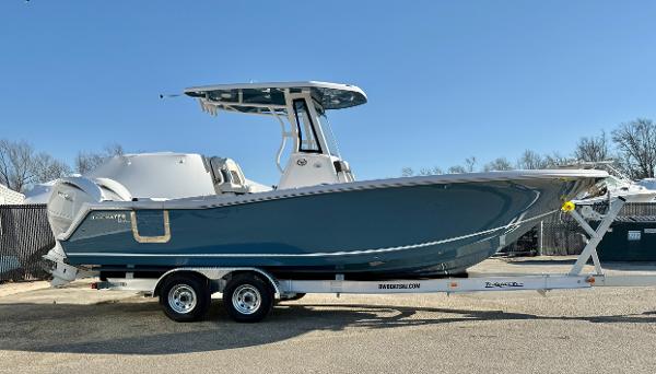 Tidewater 256 CC Adventure 2025 Tidewater 256 CC Adventure boat on trailer, side view, blue hull, clear sky background.