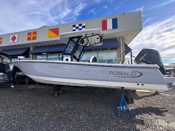 Robalo 266 Cayman 2024 Robalo 266 Cayman boat displayed outdoors with nautical flags in the background.