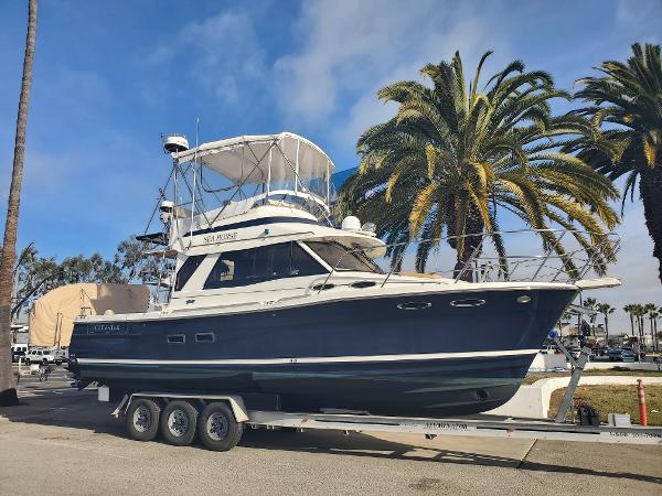 Cutwater 30 Command Bridge 2016 Cutwater 30 Command Bridge boat on trailer, palm trees in background.