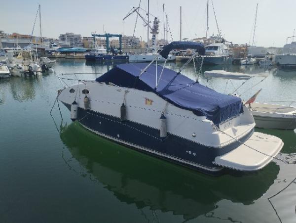 Regal 2600 1999 Regal 2600 boat docked in a marina, covered with a blue tarp.