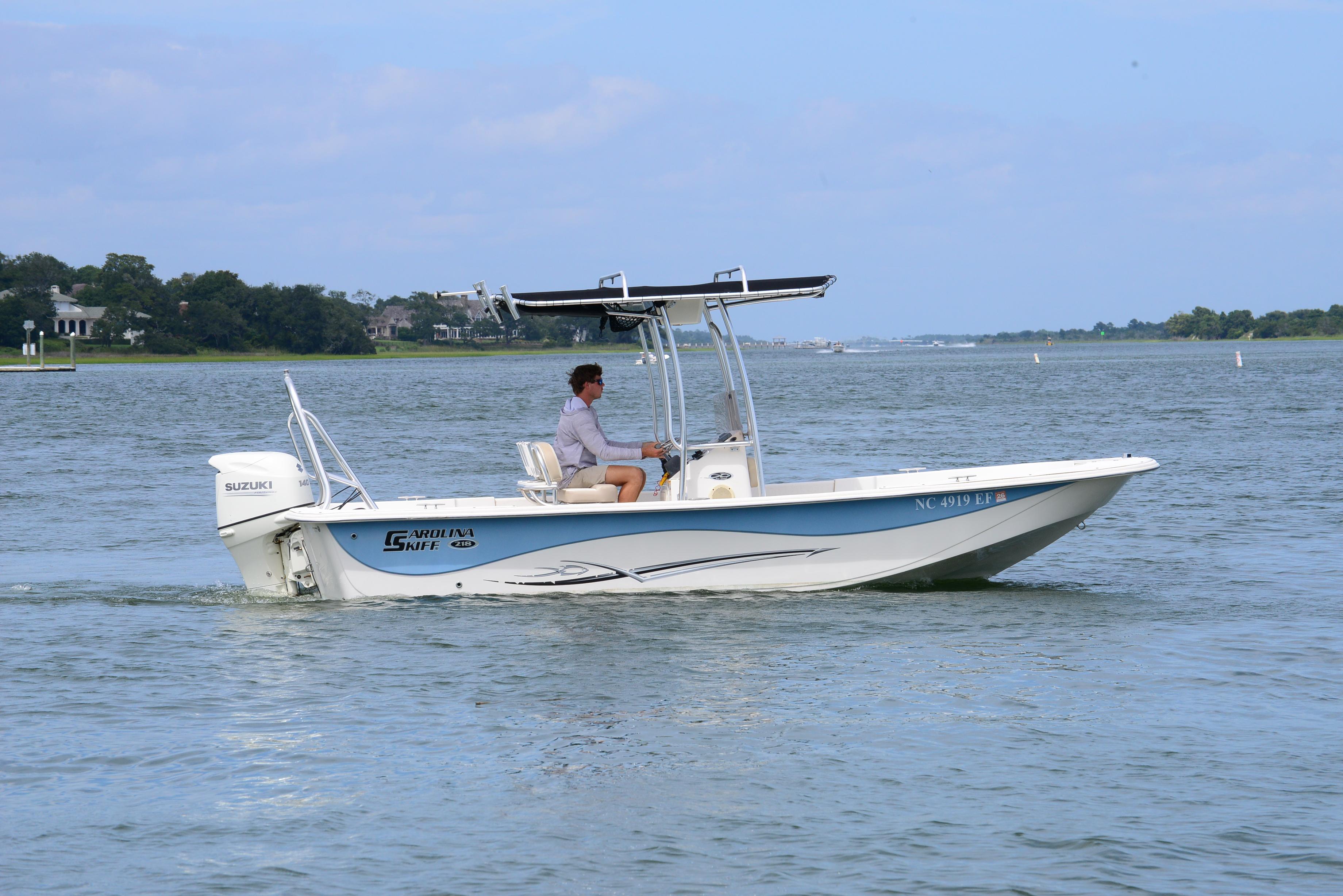 Carolina Skiff 218 DLV 2017 Carolina Skiff 218 DLV boat cruising on a calm lake with a person steering.