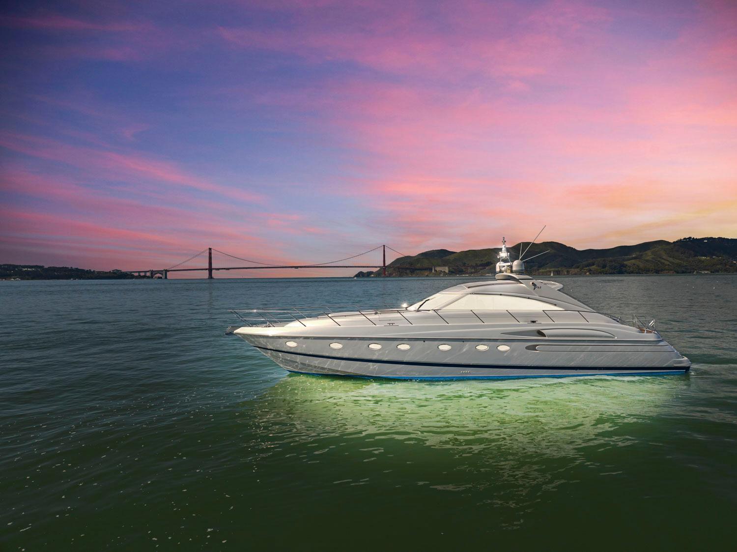 Princess 65 Luxury 2003 Princess 65 yacht at sunset near a bridge, illuminated water.