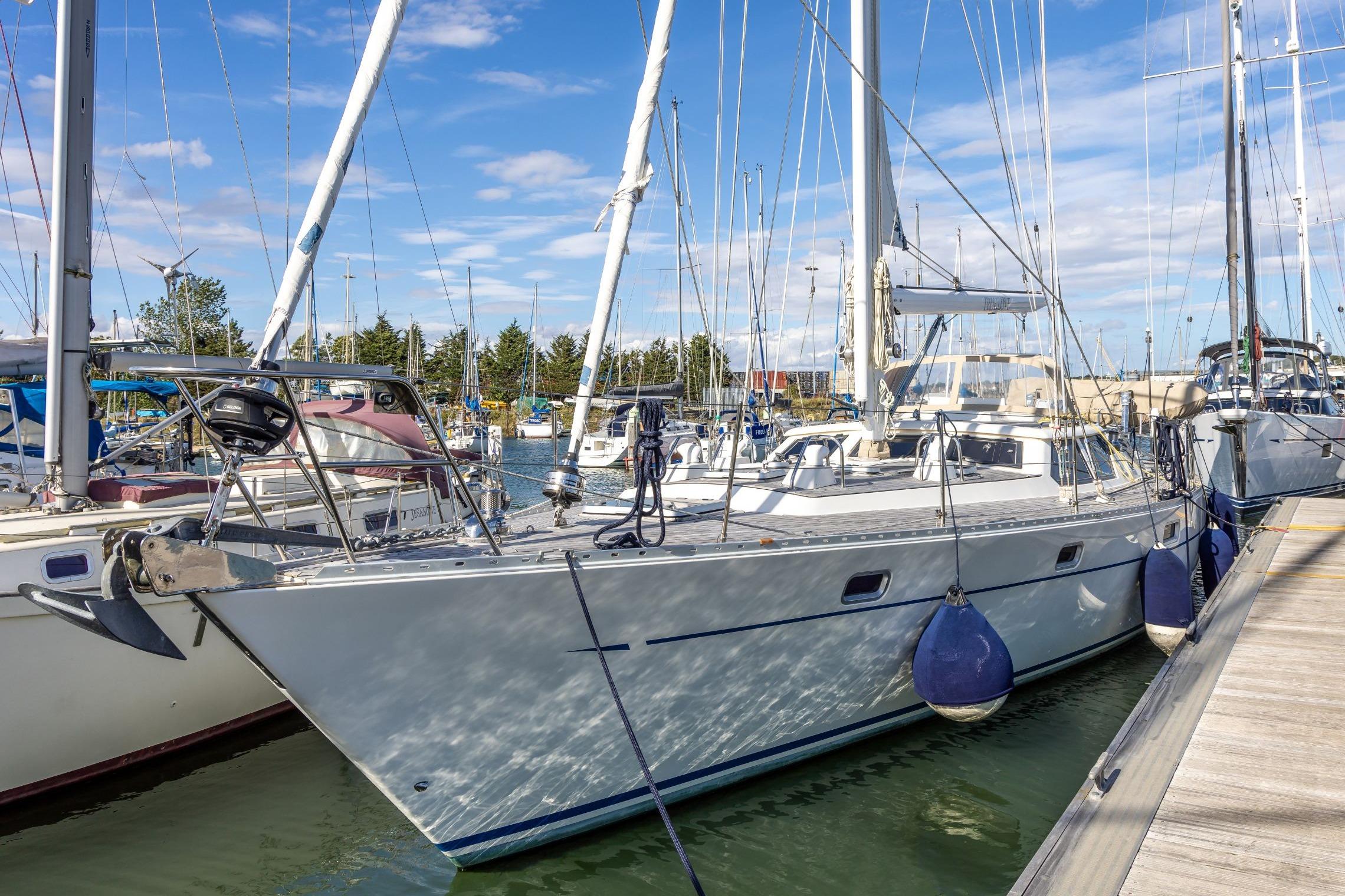 Oyster 55 Sailing yacht Oyster 55, 1994 model, docked at marina under clear blue sky.