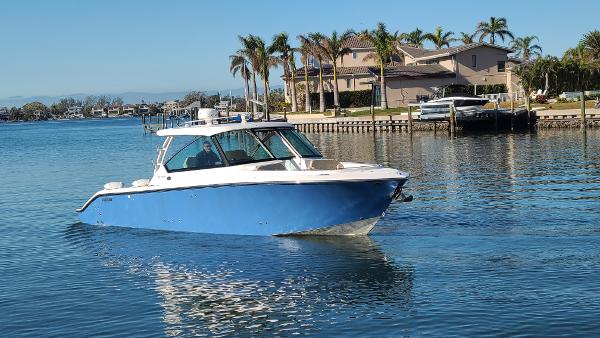 Pursuit DC 325 Dual Console 2016 Pursuit DC 325 Dual Console boat cruising on a sunny waterfront.