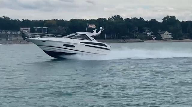 Regal 46 Sport Coupe 2017 Regal 46 Sport Coupe cruising on a lake with shoreline in the background.
