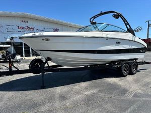 Sea Ray SLX 260 Surf 2023 Sea Ray 260 SLX boat on trailer, parked outside a building.
