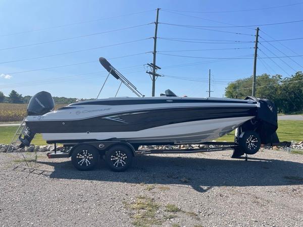 Crownline E225 XS 2023 Crownline E225 XS boat on trailer, parked outdoors under clear blue sky.
