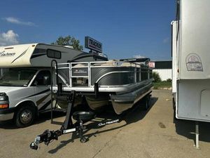 Sun Tracker Fishin' Barge 22 XP3 2025 Sun Tracker Fishin' Barge 22 XP3 pontoon boat on trailer in parking lot.