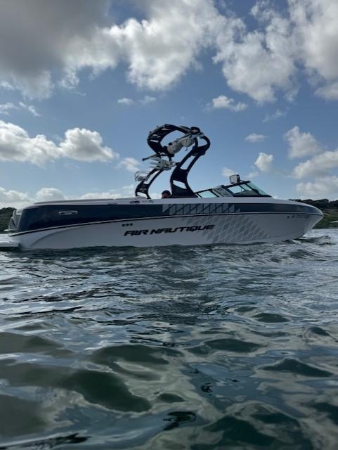 Nautique 226 2010 Nautique 226 boat on water under cloudy sky.