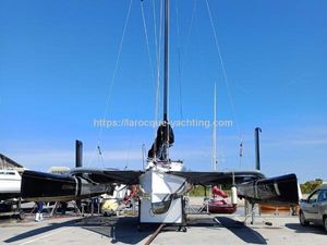 Custom SEAON 96 Custom SEAON 96 trimaran sailboat from 2006 on a dock, clear blue sky background.
