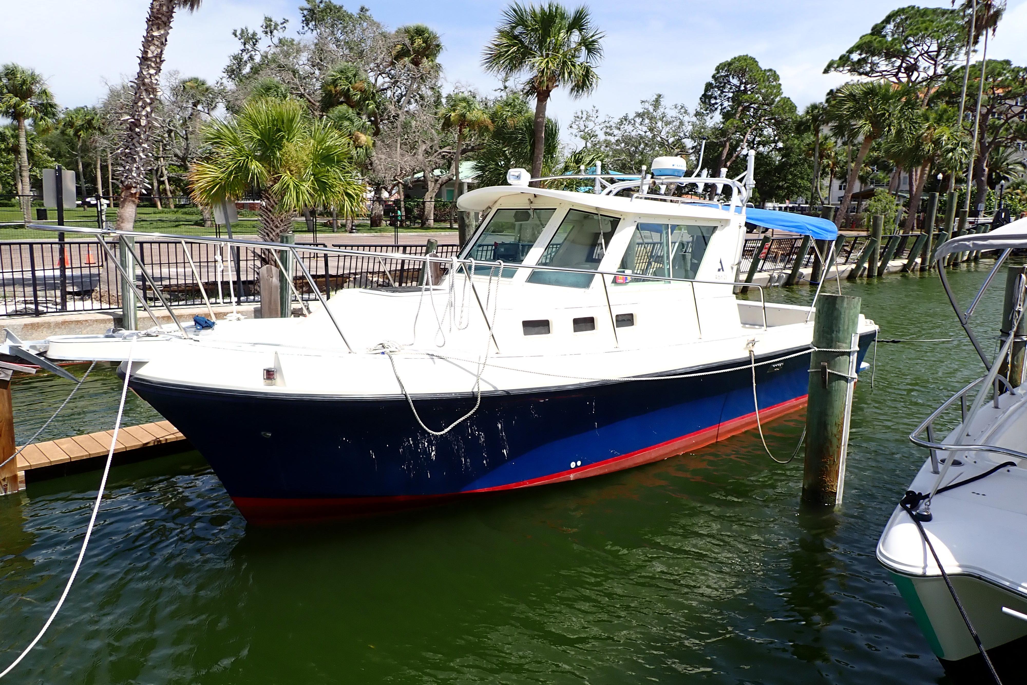 Albin 28 Tournament Express 2000 Albin 28 Tournament Express boat docked near palm trees.