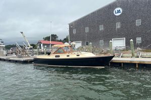 C.W. Hood Katama 30 2005 C.W. Hood Katama 30 boat docked near a large building on a cloudy day.