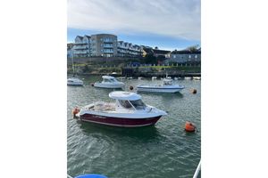 Arvor 230 AS 2007 Arvor 230 AS boat moored in a scenic harbor with modern buildings in the background.