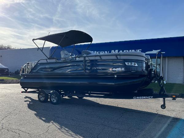 Regency 230 LE3 Sport 2023 Regency 230 LE3 Sport pontoon boat on trailer outside dealership.