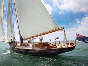 Classic Bristol Pilot Cutter Classic 1899 Bristol Pilot Cutter sailing with crew on open water under clear skies.