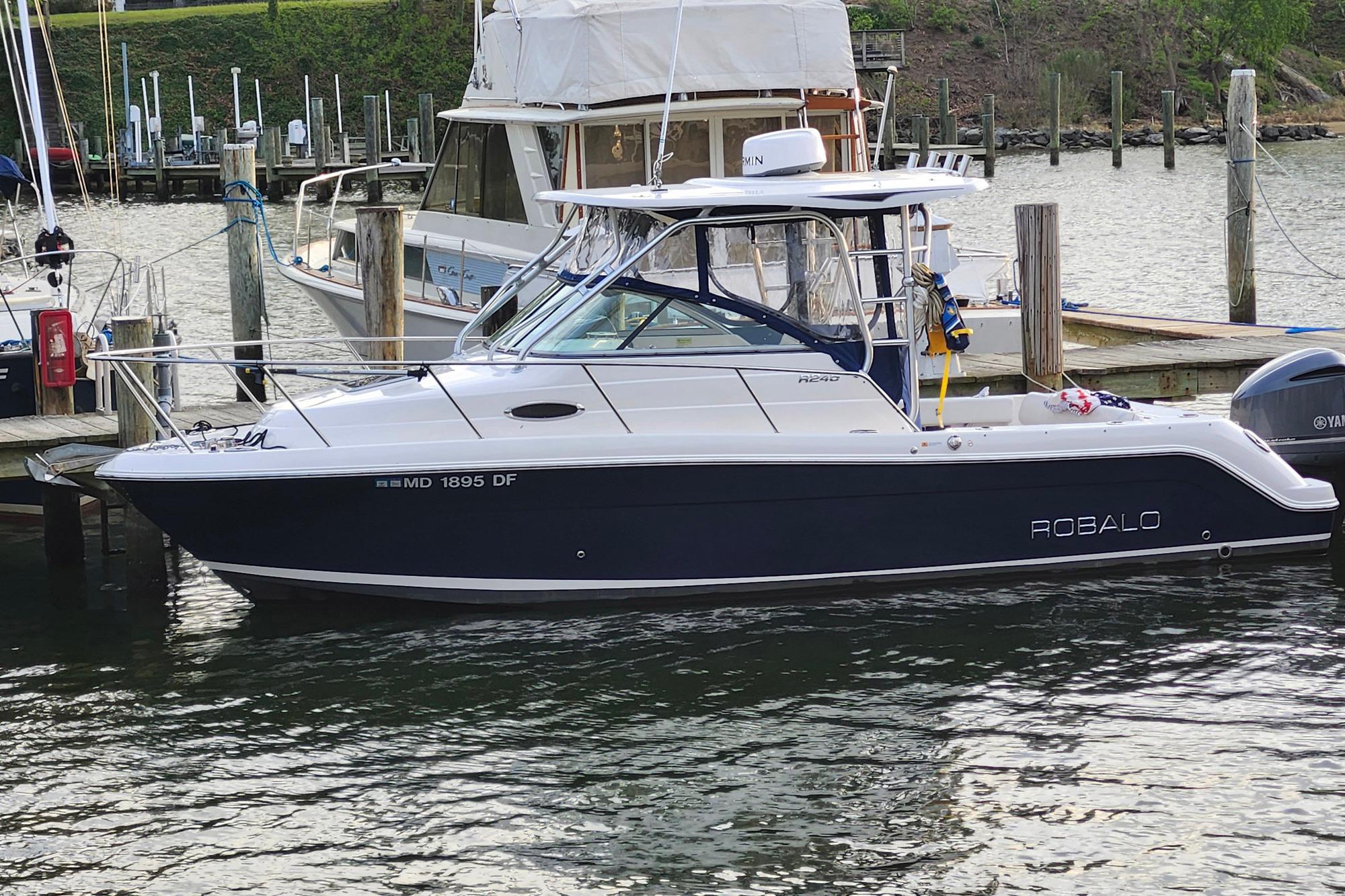 Robalo R245 Walkaround 2015 Robalo R245 Walkaround boat docked at marina, side view.