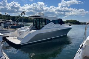 Tiara Yachts C39 Coupe 2018 Tiara Yachts C39 Coupe docked in a serene marina under a blue sky.