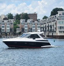 Regal 42 Sport Coupe 2014 Regal 42 Sport Coupe yacht cruising near waterfront buildings.