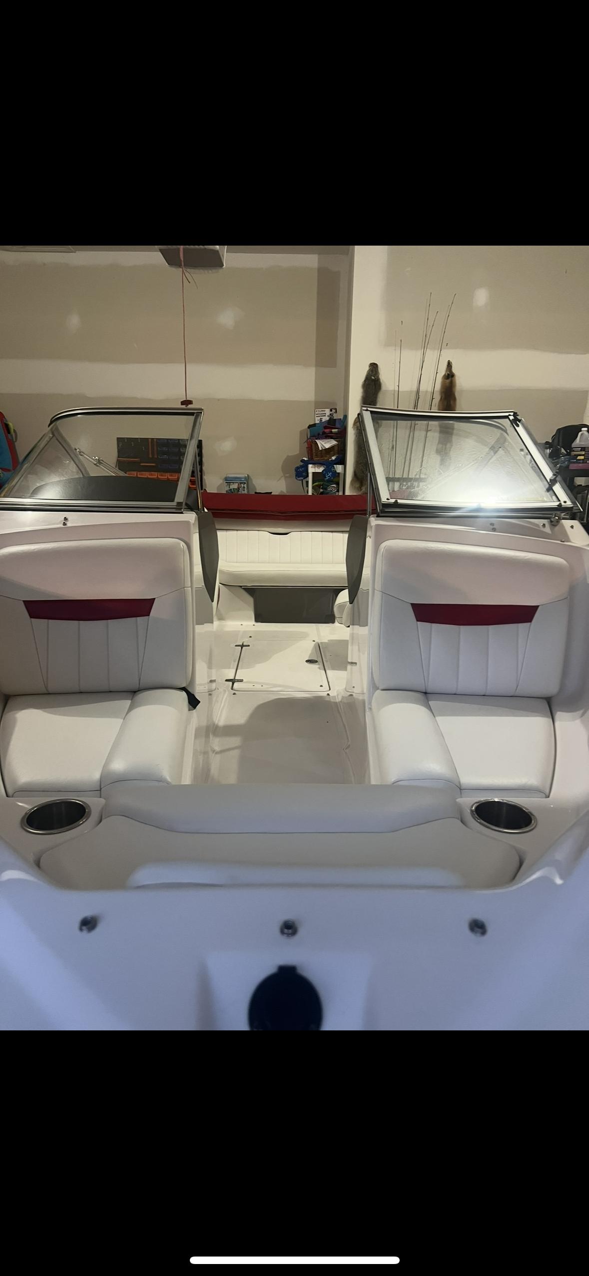 Regal 1900 Bowrider 2007 Regal 1900 Bowrider interior with white seating and windshield in a garage setting.